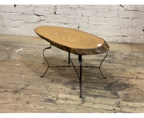 A vintage naturalistic low table, the varnished tree trunk cross section top raised on wrought iron scrolling supports, H38cm