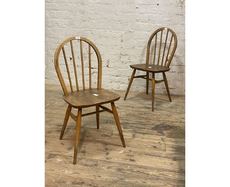 Ercol, A pair of elm and beech dining chairs, hoop and spindle back over saddle seat, raised on turned and tapered supports, 