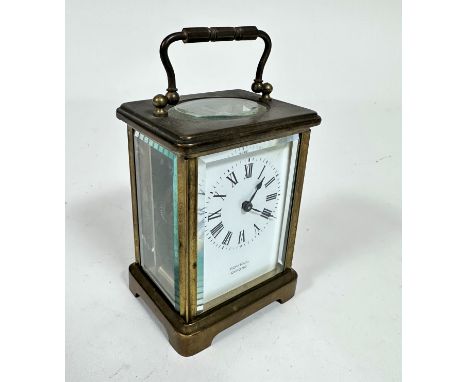 A French brass four glass carriage clock with enamelled dial, retailed by Rowell of Oxford, with arabic numerals and handle t