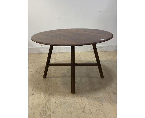 Ercol, a beech and elm extending dining table, the circular top on four splayed supports united by a crossed stretcher, H72cm