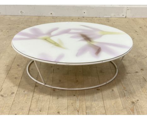 A vintage circular low table, the floral patterned acrylic top over white metal supports, H25cm, D30cm