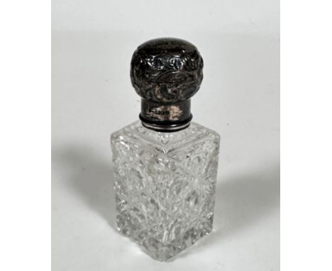 An Edwardian silver mounted crystal slice cut perfume bottle with lift up top enclosing faceted stopper, marks rubbed (11cm x