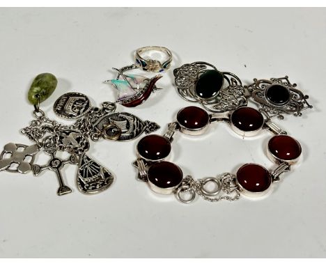 A white metal bracelet set six circular carnelian panels, a white metal oval green stone mounted Celtic style brooch, a silve