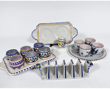 A Poole pottery 1920s / 30s stand complete with six various egg cup holders, a six division toast track, an egg cup stand com
