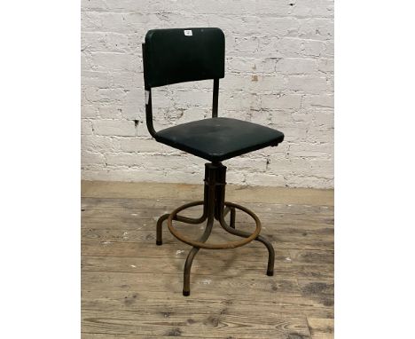 A mid century vintage machinists' chair, the green vinyl seat and back raised on a rise and fall swivel four point base with 