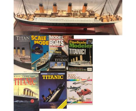 TITANIC SCALE MODEL. A scale model of the Titanic presented in a glass and wood case, along with six books/magazines relating