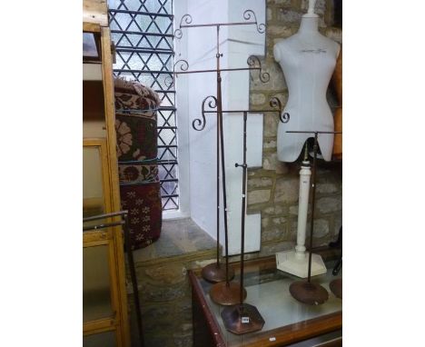 A pair of vintage anodised shop display stands with telescopic T shaped and scrolled brackets raised on simple turned columns