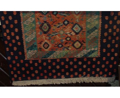 An eastern wool rug with multi coloured central panel set within a dark black border with red spot detail, 185 x 120 cm appro