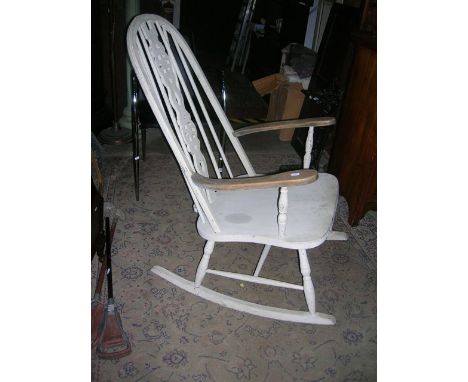 A Windsor style high hoop and stick back rocking chair with central pierced wheel splat and all over later painted finish