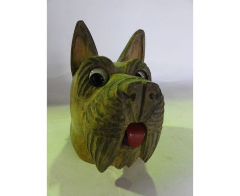 An unusual wind-up desk top bell, the carved timber case in the form of a terrier mask with inset eyes and red plastic tongue