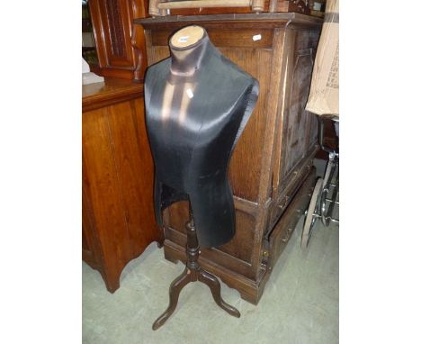 A tailors dummy/mannikin torso raised on a low stand with turned column and swept tripod