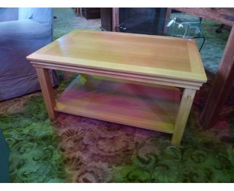 A contemporary light oak low occasional table of rectangular form on two tiers raised on square cut supports
