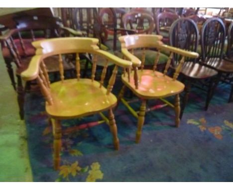 A pair of modern reproduction Windsor style smokers bow elbow chairs in light beech, with turned spindle backs