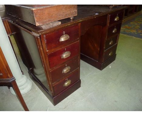 A vintage mahogany kneehole twin pedestal desk of nine drawers with brass cup handles and single drop leaf