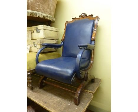 An unusual Victorian walnut rocking chair with X-shaped frame, carved detail and upholstered seat, back and arm panel