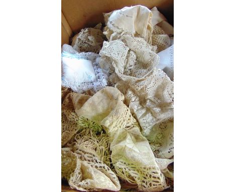 A collection of household textiles including hand embroidered cloths, lace and crocheted cloths and a basket weave bedspread 