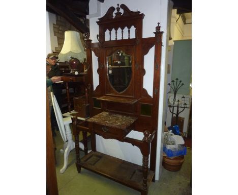 A large late Victorian walnut hallstand of full height, the raised back with architectural pediment, turned spindle gallery o