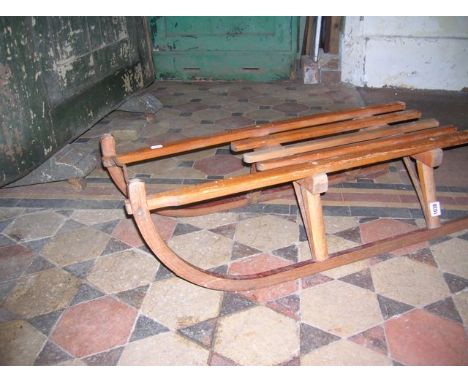 A vintage wooden toboggan with open slatted seat