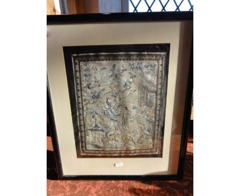 A framed and glazed Chinese silk work panel on a pale blue ground detailing figures amongst a landscape with blossoming branc