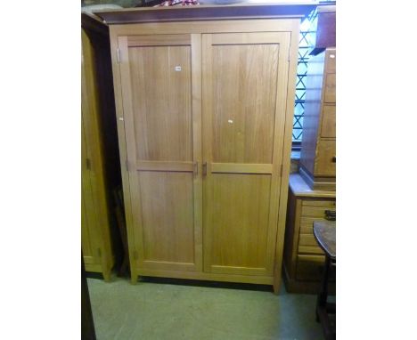 A good quality contemporary light oak bedroom pair comprising wardrobe with swept overhanging cornice, over a pair of full le