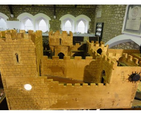 A vintage plywood model of a Medieval castle with faux brickwork paper lined and further painted finish, etc, 38 cm tall x 78