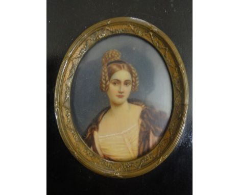 An early 20th century miniature portrait on ivorine (?) showing shoulder length portrait of a young woman in pink dress and r