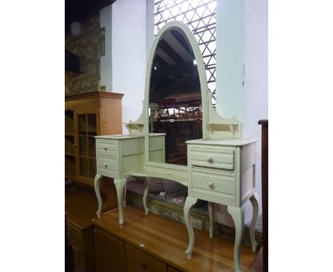 An unusual painted dressing table, the central arched bevelled edge mirror flanked by a pair of two drawer cabinets raised on