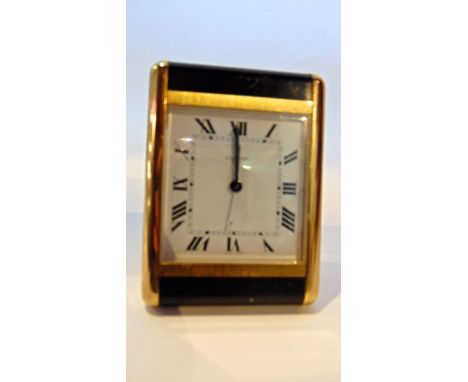 A Cartier rectangular bedside alarm clock with gilt brass and black panelled case, number 750502724 with quartz movement