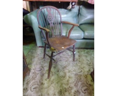 A 19th century Windsor hoop and stick back elbow chair of mixed wood construction, central pierced wheel splat over a saddle 