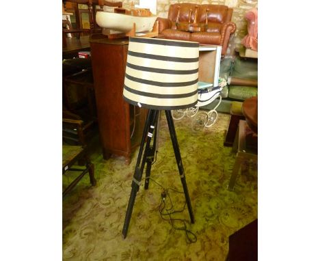 An ebonised folding tripod standard lamp and shade 