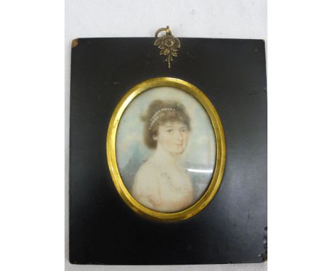 An early 19th century miniature portrait of oval form showing a bust length portrait of a young woman with pink dress and wit