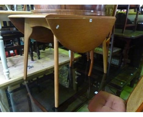 An Ercol style oval drop leaf dining table raised on splayed and tapered supports