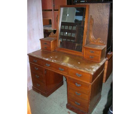 A late Victorian walnut kneehole twin pedestal dressing table with central swing mirror backsupported by shaped brackets over
