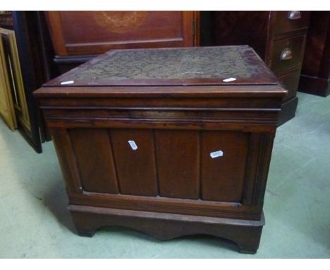 An Edwardian walnut box commode, the hinged lid with inset carpet panel, the interior with folding rests and original ceramic