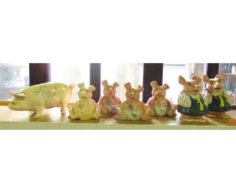 A collection of Wade NatWest pig money banks comprising two school girls and four babies together with a further ceramic pigg