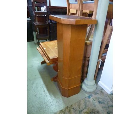 A pedestal,floorstanding of square cut and canted form beneath an elongated octagonal revolving top with inset faux leather p