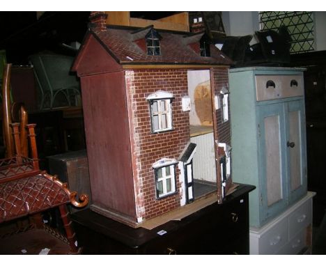 A vintage childs dolls house timber framed with hand painted simulated red brickwork façade 