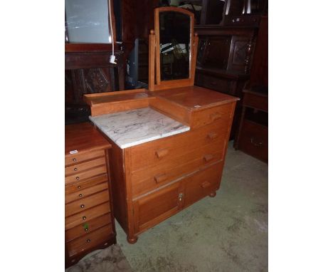 A light oak dressing  chest and combined washstand of stepped form, the arched swing mirror with bevelled edge plate over a w