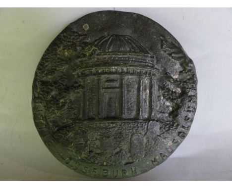 A lead panel of circular form with embossed detail - Little Duseburn Mausoleum, detailing a mausoleum flanked by trees with g