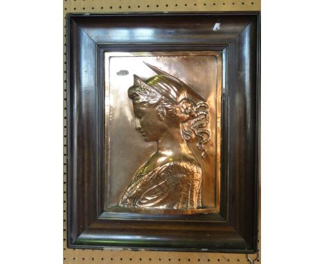 A late 19th century framed copper work panel depicting a maiden in side profile with a halo and tiara, her hair tied in a tra