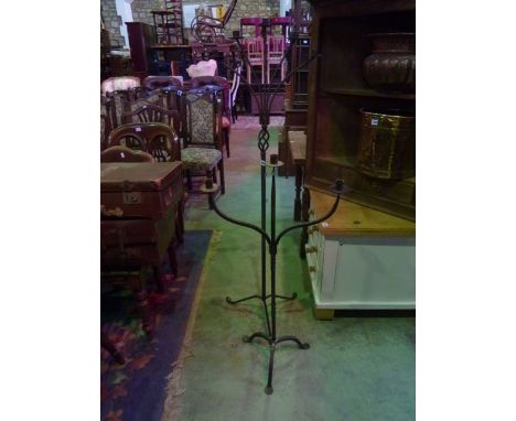An iron work floorstanding three branch candle stand raised on tripod supports together with one other 