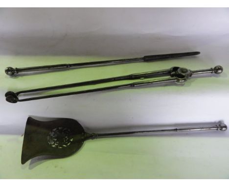 A good quality trio of ironwork fireside effects to include tongs, poker and trowel with pierced detail