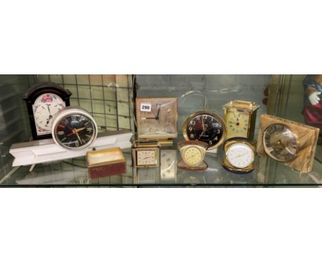 SHELF OF TRAVELLING ALARM CLOCKS, QUARTZ STYLE CARRIAGE CLOCKS AND A CALIBRE MONOPOL TABLE LIGHTER CLOCK 