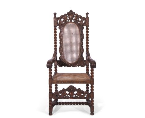 Late 19th century large oak and Bergere armchair in Carolean style, the back featuring carved detail of scrolls and two putti