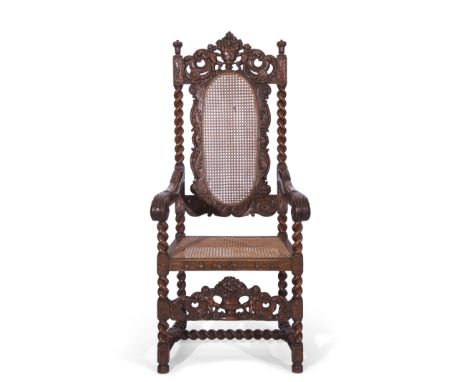 Late 19th century large oak and Bergere armchair in Carolean style, the back featuring carved detail of scrolls and two putti