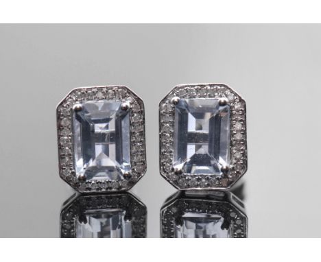 Pair of aquamarine and diamond earrings, the step aquamarines 7.09 x 4.96mm, raised within a small diamond surround, stamped 