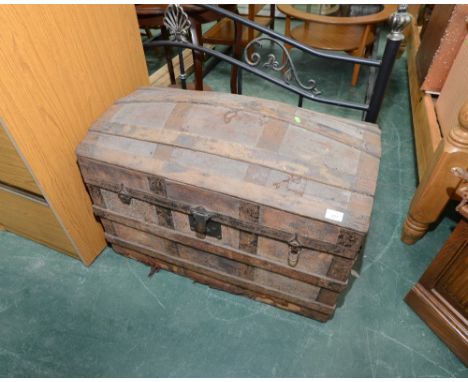 A vintage metal bound wooden dome topped travelling trunk