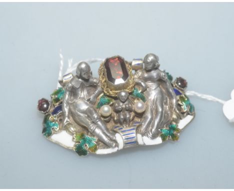 After Froment-Meurice, a striking garnet, amethyst, enamel and seed pearl brooch, cast with seated figures flanking a large c