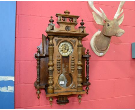 An ornate 19th century mahogany wall clock with a plethera of turned decoration