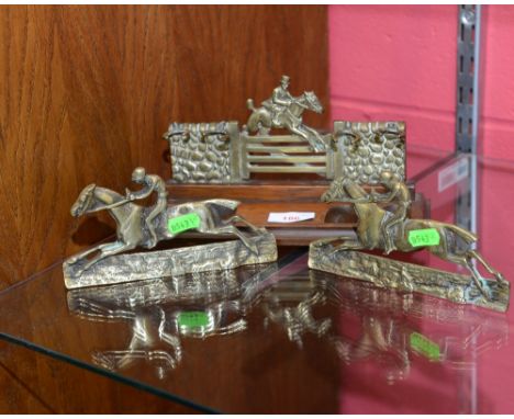 An oak and brass pipe rack, with brass hunting scene, together with two pierced brass plaques of jockeys up, (3)